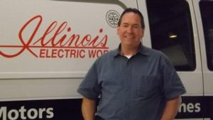mike bongner posing in front of electric vehicle